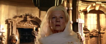 Movie still from “The Chronicles of Riddick” (2004), directed by David Twohy – An older woman wearing a head covering looking at the camera; Close Up shot, Low angle