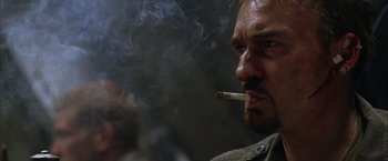 Movie still from “The Chronicles of Riddick” (2004), directed by David Twohy – A person smoking a cigarette; Close Up shot, Low angle