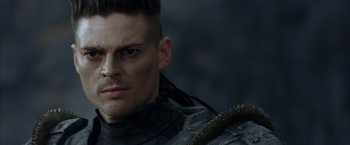 Movie still from “The Chronicles of Riddick” (2004), directed by David Twohy – A person wearing a helmet; Close Up shot, Over the shoulder angle