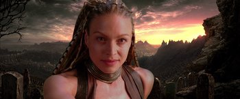 Movie still from “The Chronicles of Riddick” (2004), directed by David Twohy – A woman in a leather outfit with a mountain view in the background; Close Up shot, Low angle