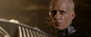 Movie still from “The Chronicles of Riddick” (2004), directed by David Twohy – A person wearing a suit and tie; Close Up shot, Low angle