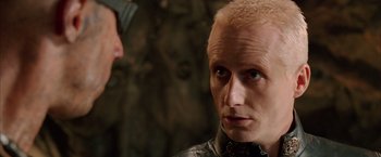 Movie still from “The Chronicles of Riddick” (2004), directed by David Twohy – A person with a bald head; Close Up shot, Over the shoulder angle