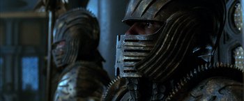Movie still from “The Chronicles of Riddick” (2004), directed by David Twohy – A person wearing a metal helmet; Close Up shot, Over the shoulder angle