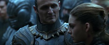 Movie still from “The Chronicles of Riddick” (2004), directed by David Twohy – A man and a woman in armor looking at each other; Close Up shot, Over the shoulder angle