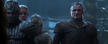 Movie still from “The Chronicles of Riddick” (2004), directed by David Twohy – Two men in armor standing next to each other; Close Up shot, Over the shoulder angle