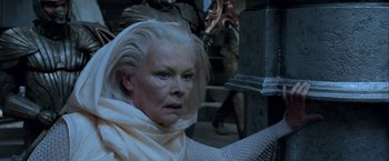 Movie still from “The Chronicles of Riddick” (2004), directed by David Twohy – An older woman with white hair and a white scarf; Close Up shot, Low angle