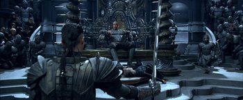 Movie still from “The Chronicles of Riddick” (2004), directed by David Twohy – A man sitting on top of a chair in a room; Wide shot, High angle