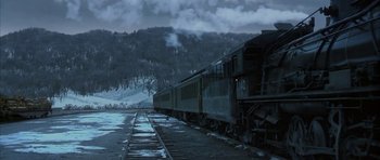 Movie still from “The Cider House Rules” (1999), directed by Lasse Hallström – A train traveling down train tracks next to snow covered trees; Extreme Wide shot, High angle