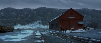 Movie still from “The Cider House Rules” (1999), directed by Lasse Hallström – Two people are standing on the train tracks near a train station; Extreme Wide shot, High angle