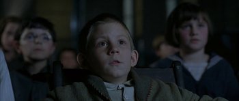 Movie still from “The Cider House Rules” (1999), directed by Lasse Hallström – A young boy sitting in a chair looking up; Close Up shot, Low angle