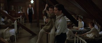 Movie still from “The Cider House Rules” (1999), directed by Lasse Hallström – A man holding a child on top of a wooden pole; Medium shot, Low angle