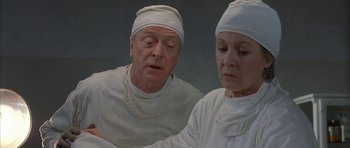 Movie still from “The Cider House Rules” (1999), directed by Lasse Hallström – A man and a woman wearing white medical clothing; Medium shot, Over the shoulder angle