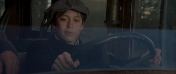 Movie still from “The Cider House Rules” (1999), directed by Lasse Hallström – A young boy in a hat driving a car; Close Up shot, Low angle