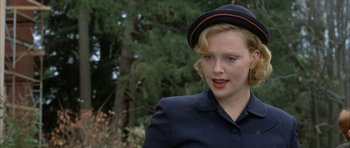 Movie still from “The Cider House Rules” (1999), directed by Lasse Hallström – A woman wearing a hat standing next to a tree; Close Up shot, Over the shoulder angle