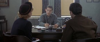 Movie still from “The Cider House Rules” (1999), directed by Lasse Hallström – A man sitting at a table writing on a piece of paper; Medium shot, Over the shoulder angle
