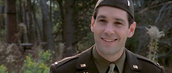 Movie still from “The Cider House Rules” (1999), directed by Lasse Hallström – A man in a military uniform smiling for the camera; Close Up shot, Over the shoulder angle