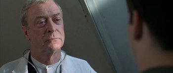 Movie still from “The Cider House Rules” (1999), directed by Lasse Hallström – An older man with a stethoscope around his neck; Close Up shot, Low angle