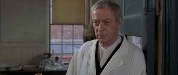 Movie still from “The Cider House Rules” (1999), directed by Lasse Hallström – An older man wearing a white lab coat; Close Up shot, Over the shoulder angle