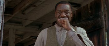 Movie still from “The Cider House Rules” (1999), directed by Lasse Hallström – A black man in a vest and a white shirt; Close Up shot, Low angle