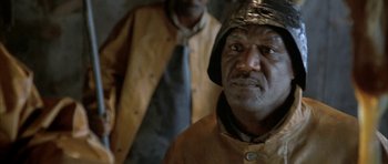 Movie still from “The Cider House Rules” (1999), directed by Lasse Hallström – A man wearing a gold hat and a yellow jacket; Close Up shot, High angle