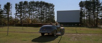 Movie still from “The Cider House Rules” (1999), directed by Lasse Hallström – A couple of people in the back of an old car; Extreme Wide shot, High angle