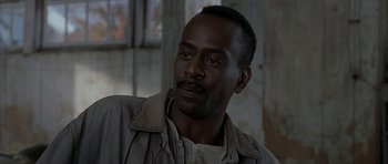 Movie still from “The Cider House Rules” (1999), directed by Lasse Hallström – A man with a beard is looking into the distance; Close Up shot, Over the shoulder angle