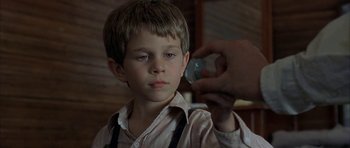 Movie still from “The Cider House Rules” (1999), directed by Lasse Hallström – A young boy is looking into the camera; Close Up shot, Over the shoulder angle