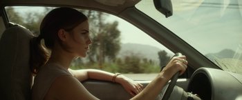 Movie still from “The Circle” (2017), directed by James Ponsoldt – A woman sitting in the driver's seat of a car driving down a street; Close Up shot, Low angle