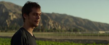 Movie still from “The Circle” (2017), directed by James Ponsoldt – A man standing in front of a field with mountains in the background; Close Up shot, Over the shoulder angle