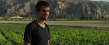 Movie still from “The Circle” (2017), directed by James Ponsoldt – A man standing in front of a lush green field; Close Up shot, Over the shoulder angle