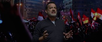 Movie still from “The Circle” (2017), directed by James Ponsoldt – A man standing in front of a crowd of people holding flags; Close Up shot, Over the shoulder angle