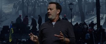 Movie still from “The Circle” (2017), directed by James Ponsoldt – A man standing in front of a crowd of people; Medium shot, Over the shoulder angle