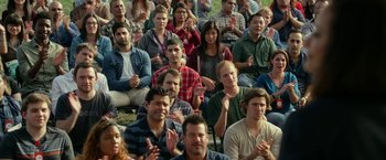 Movie still from “The Circle” (2017), directed by James Ponsoldt – A large group of people sitting in the grass clapping; Wide shot, High angle