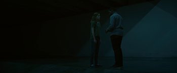 Movie still from “The Circle” (2017), directed by James Ponsoldt – A man and a woman standing next to each other in a dark room; Medium shot, Low angle