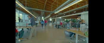 Movie still from “The Circle” (2017), directed by James Ponsoldt – A group of people sitting at tables in an office building; Extreme Wide shot, High angle