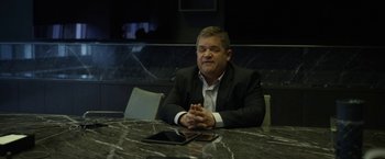 Movie still from “The Circle” (2017), directed by James Ponsoldt – A man sitting at a table in front of an ipad; Medium shot, Over the shoulder angle