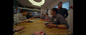 Movie still from “The Circle” (2017), directed by James Ponsoldt – A group of people sitting around a table with ipads; Wide shot, Over the shoulder angle