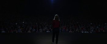 Movie still from “The Circle” (2017), directed by James Ponsoldt – A woman standing in front of a crowd of people at night; Extreme Wide shot, Low angle