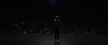 Movie still from “The Circle” (2017), directed by James Ponsoldt – A woman standing on a stage in front of an audience; Extreme Wide shot, High angle