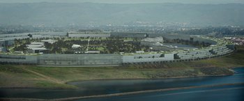 Movie still from “The Circle” (2017), directed by James Ponsoldt – An aerial view of an industrial area near a river; Extreme Wide shot, High angle