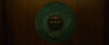 Movie still from “The Circle” (2017), directed by James Ponsoldt – A door knocker on a door knob; Extreme Close Up shot, Overhead angle