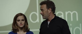 Movie still from “The Circle” (2017), directed by James Ponsoldt – A man and a woman standing next to each other in front of a wall; Close Up shot, Over the shoulder angle