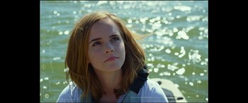 Movie still from “The Circle” (2017), directed by James Ponsoldt – A woman with long brown hair is standing in front of the water; Close Up shot, Over the shoulder angle