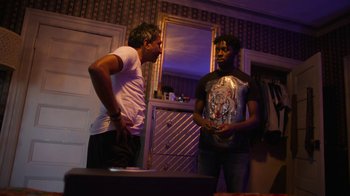 Movie still from “Full Circle” (2023), directed by Steven Soderbergh – Two men standing next to each other in front of a mirror; Medium shot, Over the shoulder angle