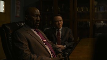 Movie still from “Full Circle” (2023), directed by Steven Soderbergh – A man in a suit and tie next to another man in a suit and tie; Medium shot, Over the shoulder angle