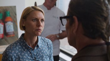 Movie still from “Full Circle” (2023), directed by Steven Soderbergh – A woman in a blue shirt is talking to a man in glasses; Close Up shot, Over the shoulder angle