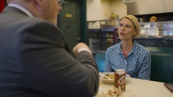 Movie still from “Full Circle” (2023), directed by Steven Soderbergh – A woman sitting at a table in front of a man; Medium shot, Over the shoulder angle