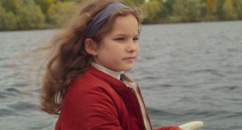 Movie still from “Petite Maman” (2021), directed by Céline Sciamma – A little girl sitting on a boat in the middle of the water; Close Up shot, High angle