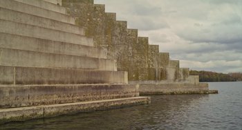 Movie still from “Petite Maman” (2021), directed by Céline Sciamma – A concrete staircase next to a body of water; Extreme Wide shot, Low angle
