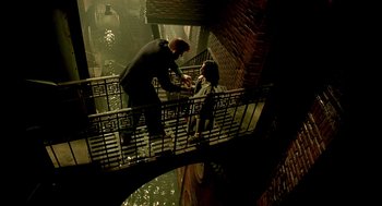 Movie still from “The City of Lost Children” (1995), directed by Jean-Pierre Jeunet – A man and a woman standing on a staircase; Extreme Wide shot, Overhead angle